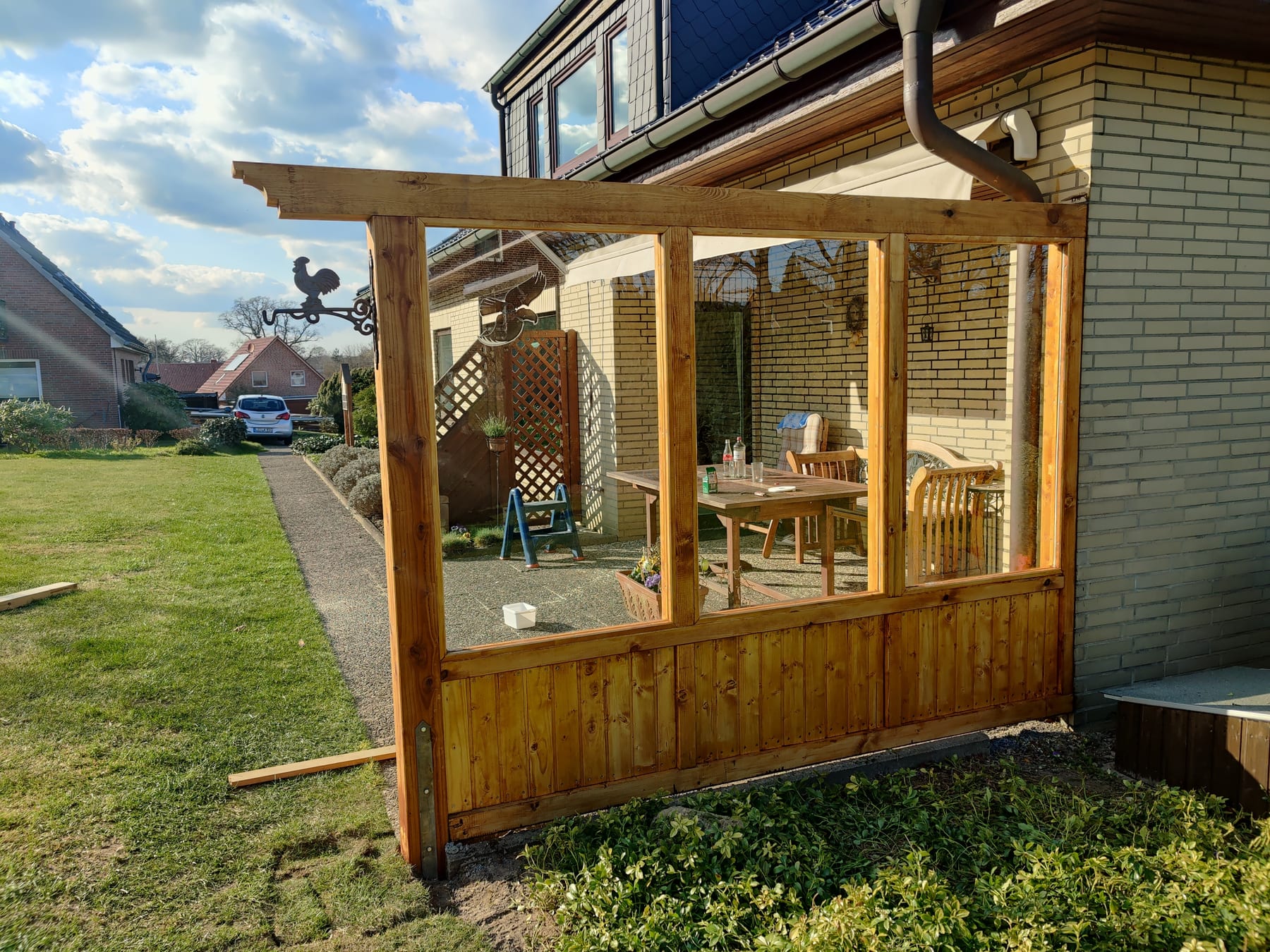 Seitliche Ansicht einer überdachten Holzterrasse am Wohnhaus