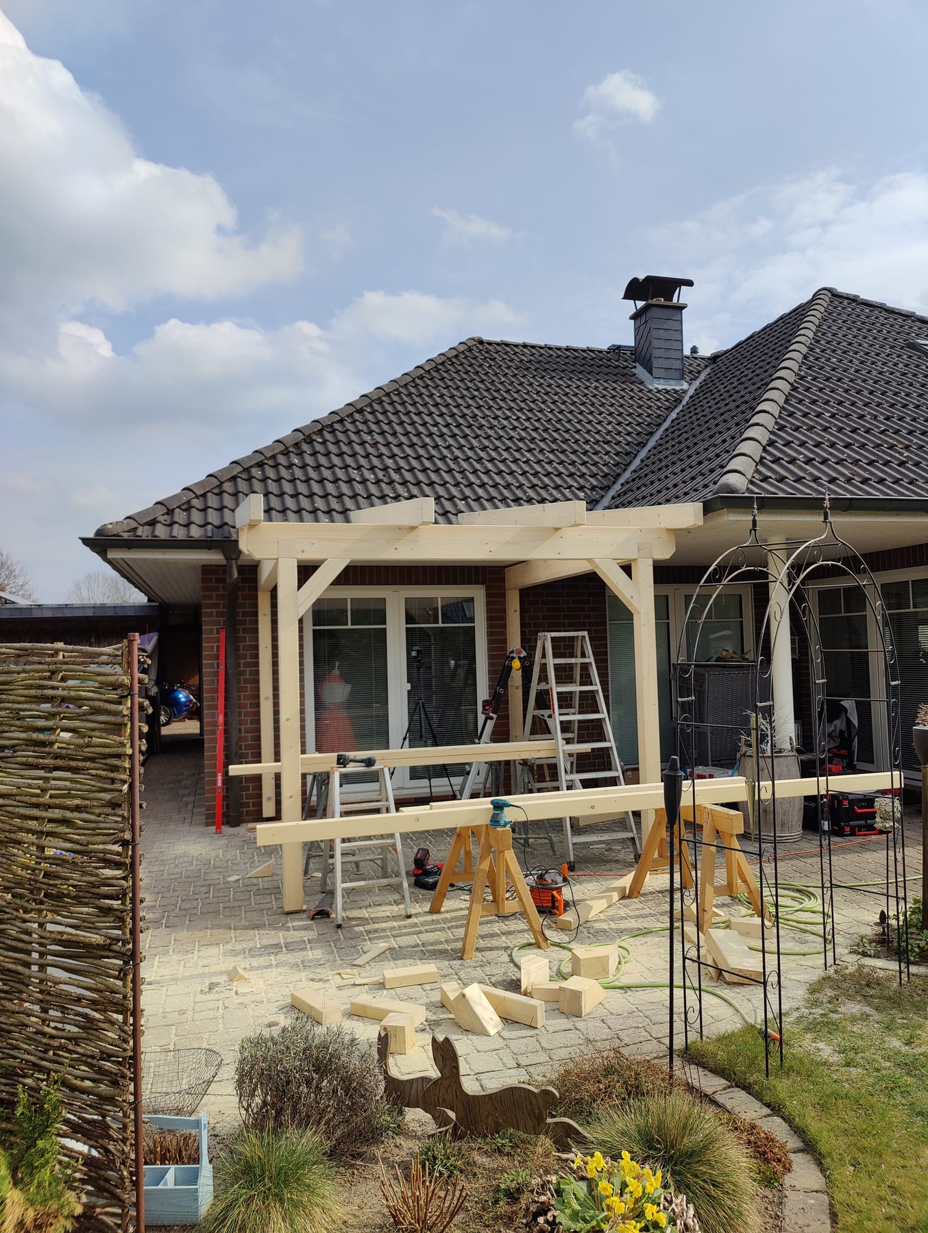 Terrassenüberdachung aus Holz am Wohnhaus mit Gerüst