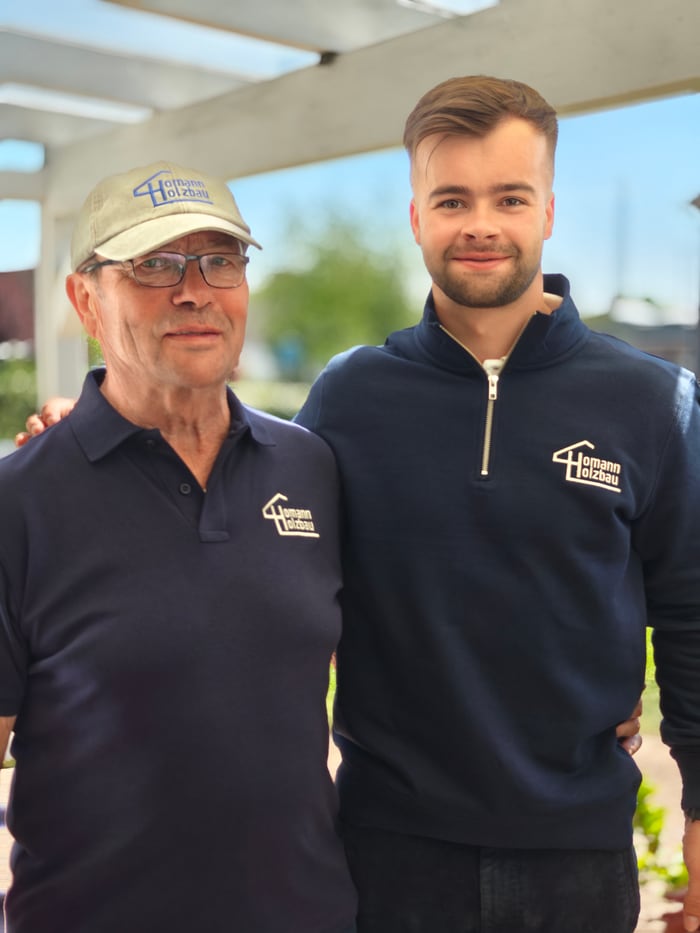 Leon Homann mit seinem Opa, beide im Homann Holzbau Outfit